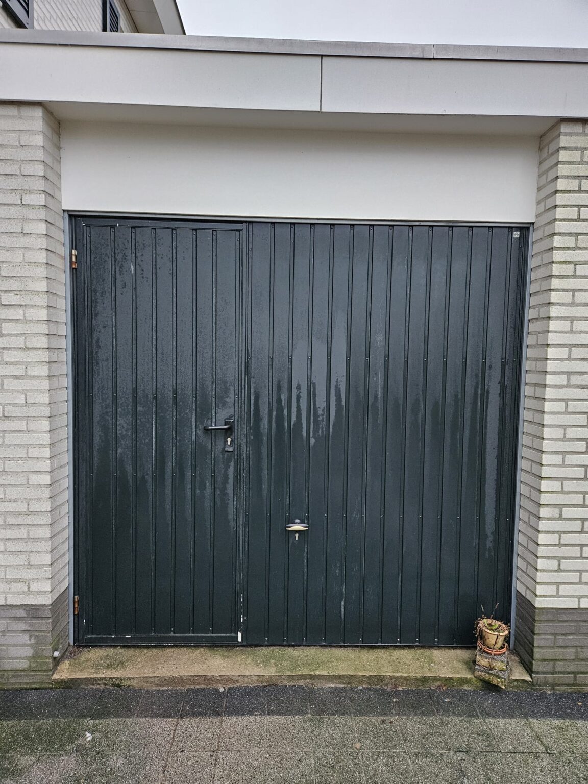 De oude garagedeur van cliënt vóór de transformatie.