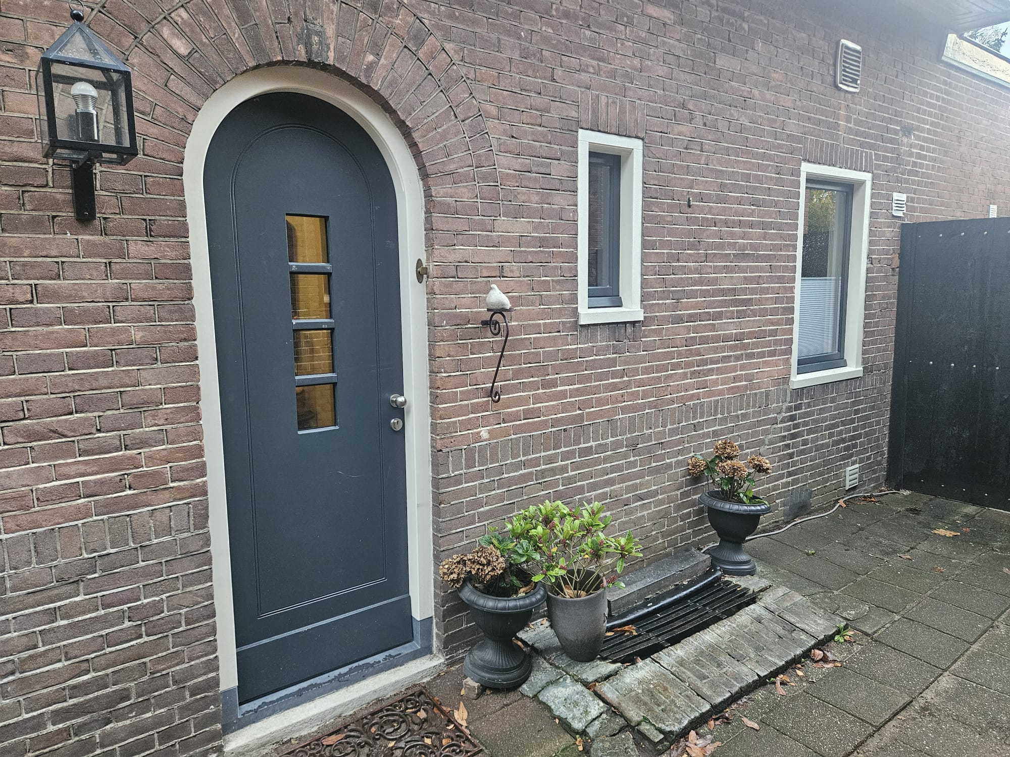 Rond deurkozijn met een passend raamkozijn er naast.